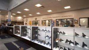 Glass cases of handguns and rifles displayed at Green Top Shooting Range rentals counter.