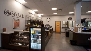 Rentals counter at Green Top Shooting Range with rifles on display wall and glass cases of handguns.